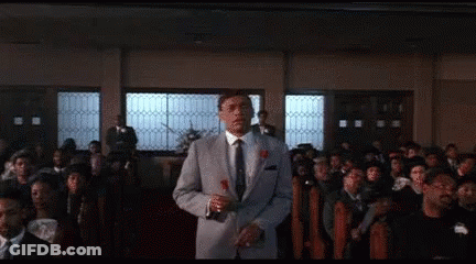 Man In Suit Holding Rose In Front Of Crowd GIF