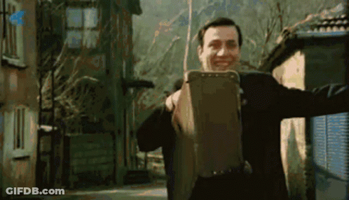 Man In Suit Holding Suitcase Smiling GIF