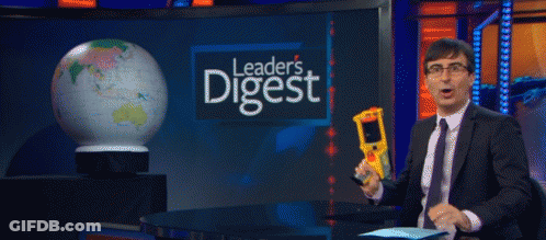 Man In Suit Holding Thermometer In Front Of Leader's Digest Sign GIF