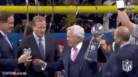 Man In Suit Holding Trophy Next To Another Man GIF