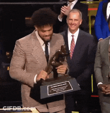 Man In Suit Holding Trophy With Plaque GIF