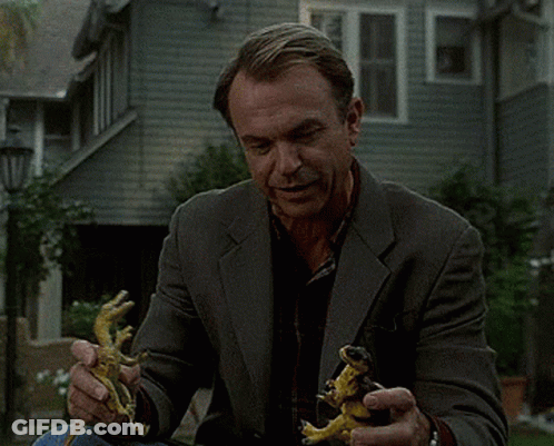Man In Suit Holding Two Lizards GIF