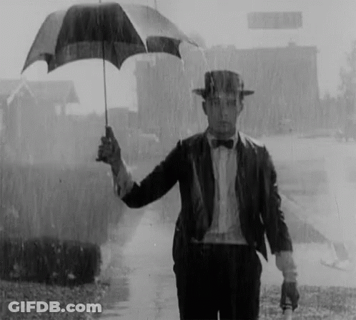 Man In Suit Holding Umbrella In Rain GIF