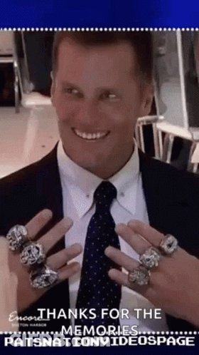 Man In Suit Holding Up Rings On Fingers GIF