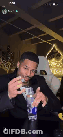 Man In Suit Holding Water And Smoking Cigarette GIF