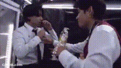 Man In Suit Holding Water Bottle Another Man Watching GIF
