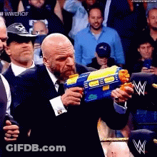 Man In Suit Holding Water Gun GIF