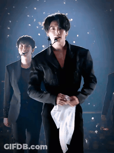 Man In Suit Holding White Towel Around Waist GIF