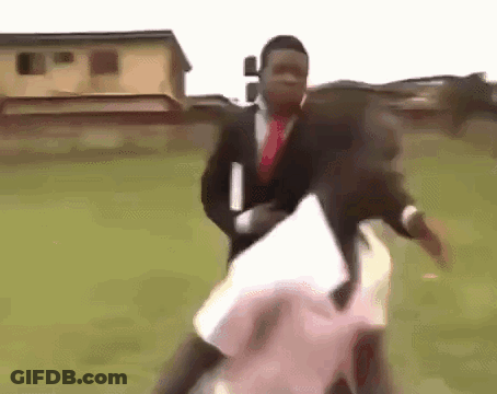 Man In Suit Holding Woman In Field GIF