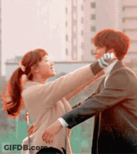 Man In Suit Holding Woman Talking On Phone GIF