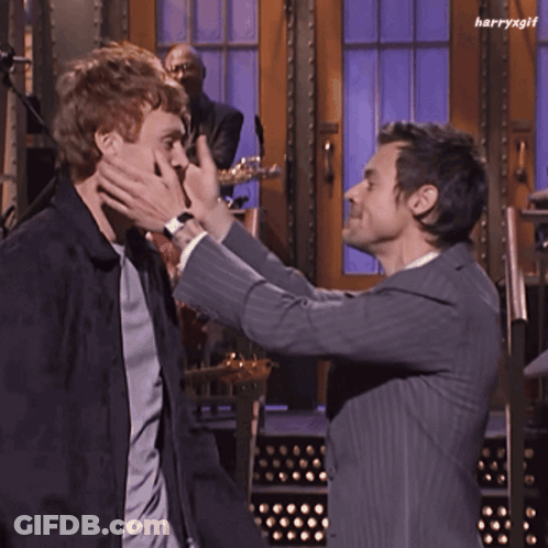 Man In Suit Hugging Another Man In Front Of Band GIF