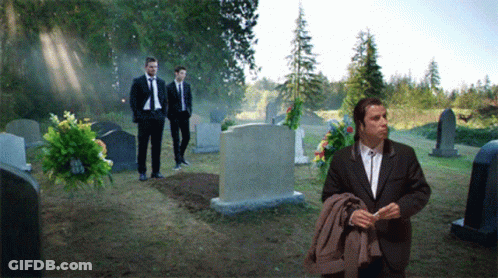 Man In Suit In Cemetery With Others GIF