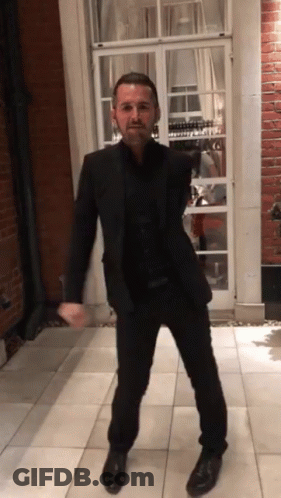 Man In Suit In Front Of Brick Building GIF