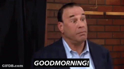 Man In Suit In Front Of Brick Wall Says Good Morning GIF