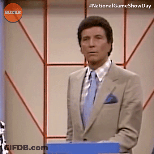 Man In Suit In Front Of Buzzr Sign GIF