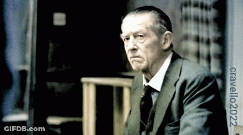 Man In Suit In Front Of Cravello 2002 Sign GIF