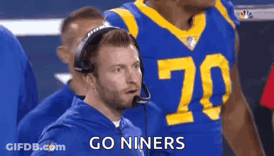 Man In Suit In Front Of Los Angeles Rams Logo GIF