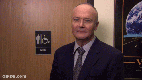 Man In Suit In Front Of Men's Restroom GIF