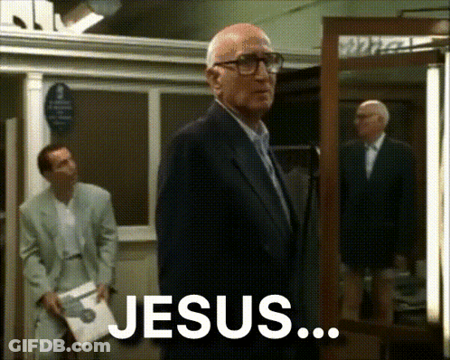 Man In Suit In Front Of Mirror Saying Jesus GIF