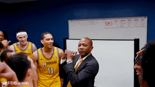 Man In Suit In Front Of Missouri Players GIF