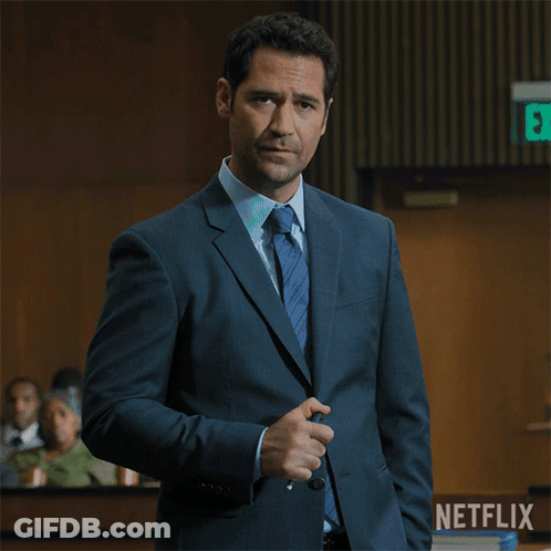 Man In Suit In Front Of Netflix Logo GIF