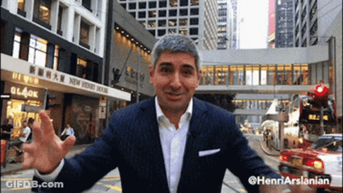 Man In Suit In Front Of New Penny House Building GIF