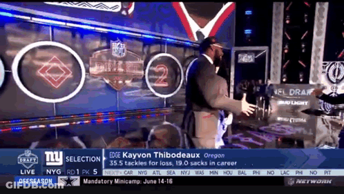 Man In Suit In Front Of NFL Draft Wall GIF