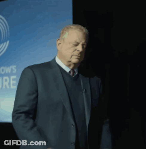 Man In Suit In Front Of OWS Sign GIF