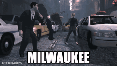 Man In Suit In Front Of Police Car With Milwaukee GIF