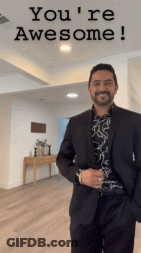 Man In Suit In Front Of Sign That Says You're Awesome GIF