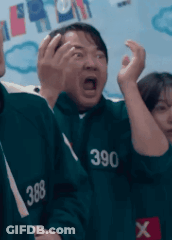 Man In Suit In Front Of Squid Game 3 Sign GIF