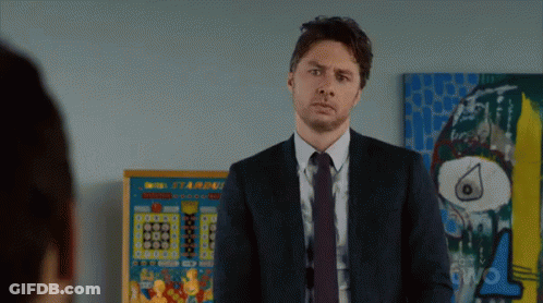 Man In Suit In Front Of Starburst Pinball Machine GIF