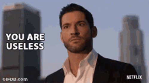 Man In Suit In Front Of Tall Buildings Says You Are Useless GIF