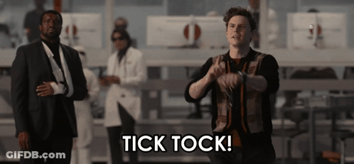 Man In Suit In Front Of Tick Tock Sign GIF