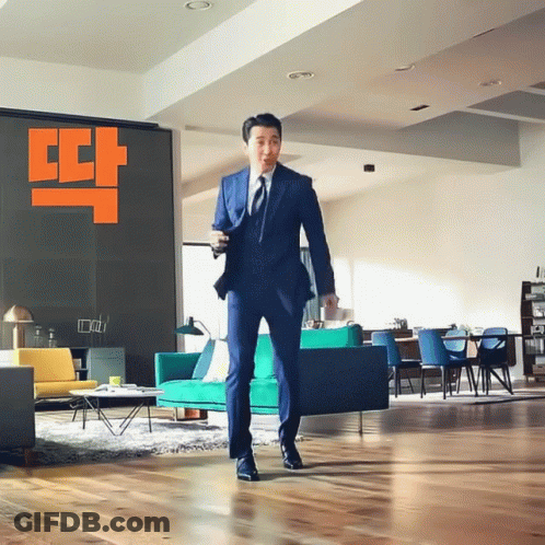 Man In Suit In Living Room With Couch GIF