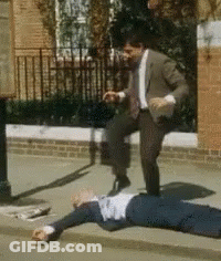 Man In Suit Kicking Another Man On Sidewalk GIF