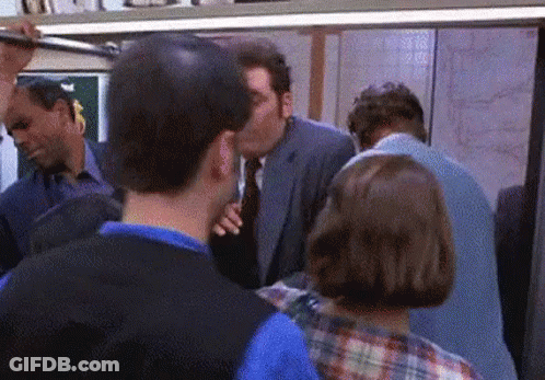 Man In Suit Kissing Another On Subway GIF
