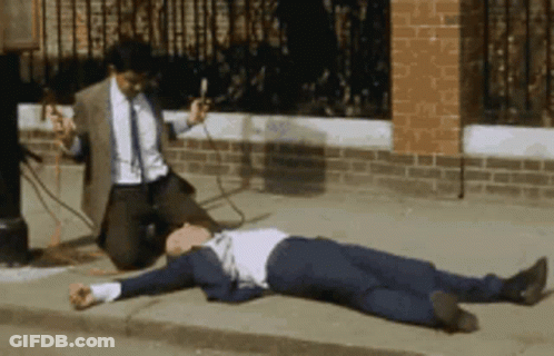 Man In Suit Kneeling Beside Man On Sidewalk GIF