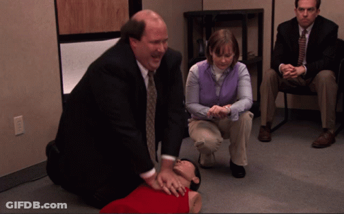 Man In Suit Kneeling Next To Woman In Purple Vest GIF
