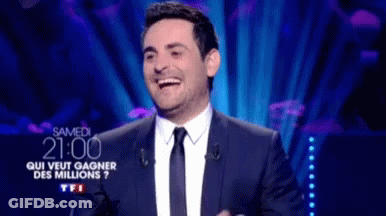Man In Suit Laughing At Screen GIF
