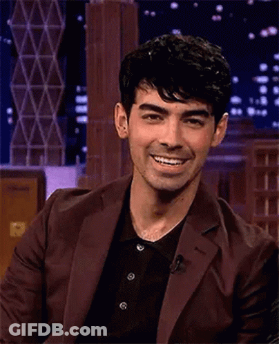 Man In Suit Laughing Eyes Closed On Stage GIF