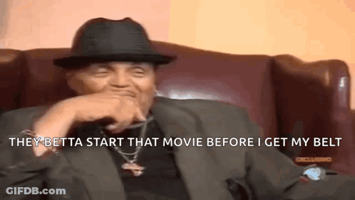 Man In Suit Laughing On Couch GIF