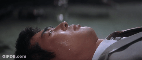 Man In Suit Laying Down With Sweat On Face GIF