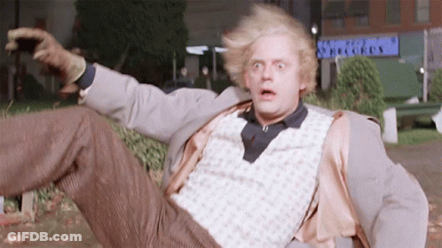 Man In Suit Laying On Ground In Front Of Records Building GIF