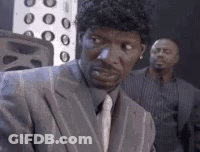 Man In Suit Looking At Camera With Another Man Behind GIF
