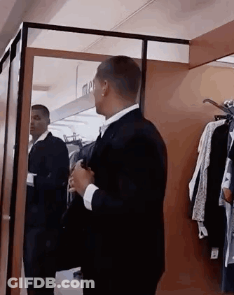 Man In Suit Looking At Himself In Mirror GIF