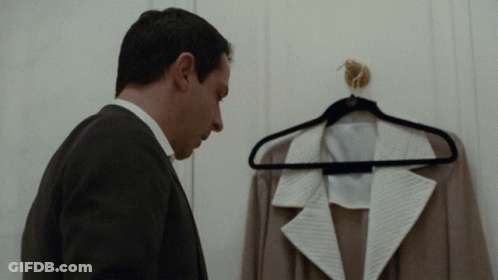 Man In Suit Looking At Jacket On Hanger GIF