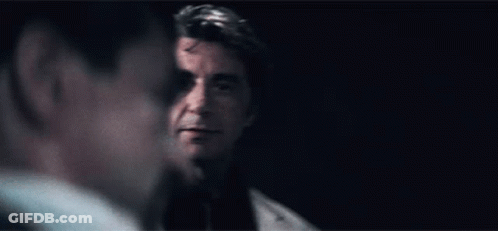 Man In Suit Looking At Man In Dark Room GIF