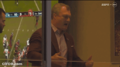 Man In Suit Looking Out Window At Football Game On ESPN On ABC GIF