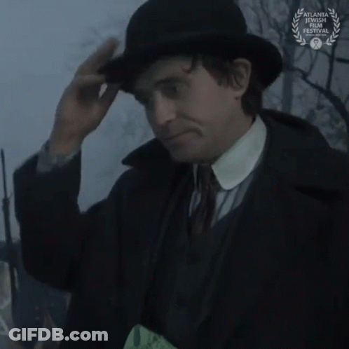 Man In Suit Looking Through Magnifying Glass With Laurel Wreath GIF
